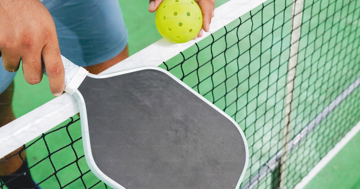 A player gripping a paddle, set for an aggressive net play