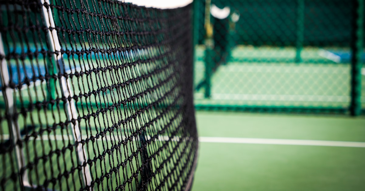 A white pickleball net stretched across a green court