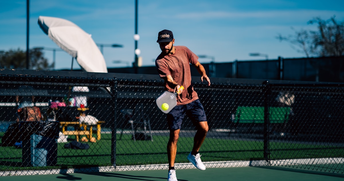 A man on a pickleball court holding a paddle