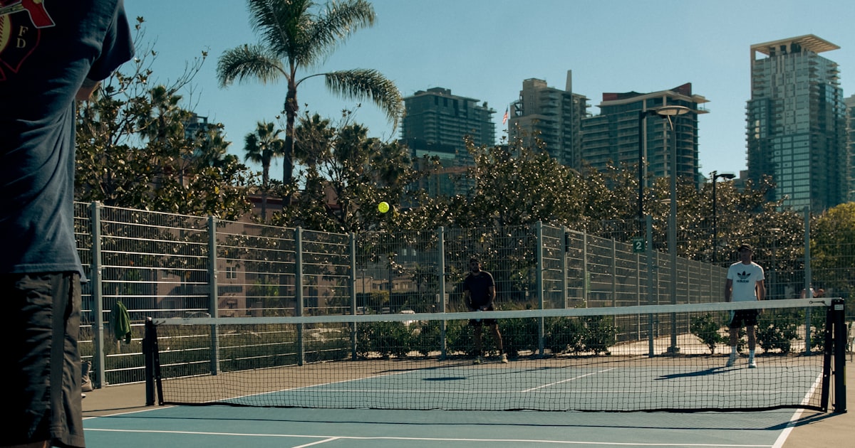 A man holding a pickleball paddle on a court