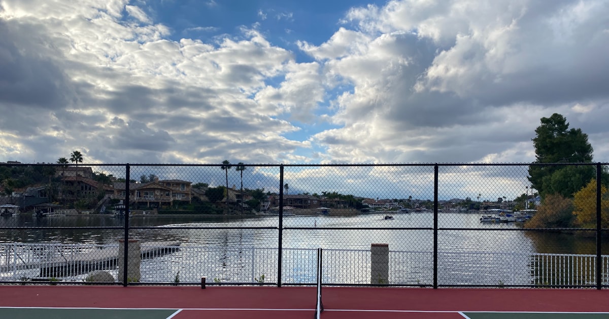 A pickleball court next to a body of water