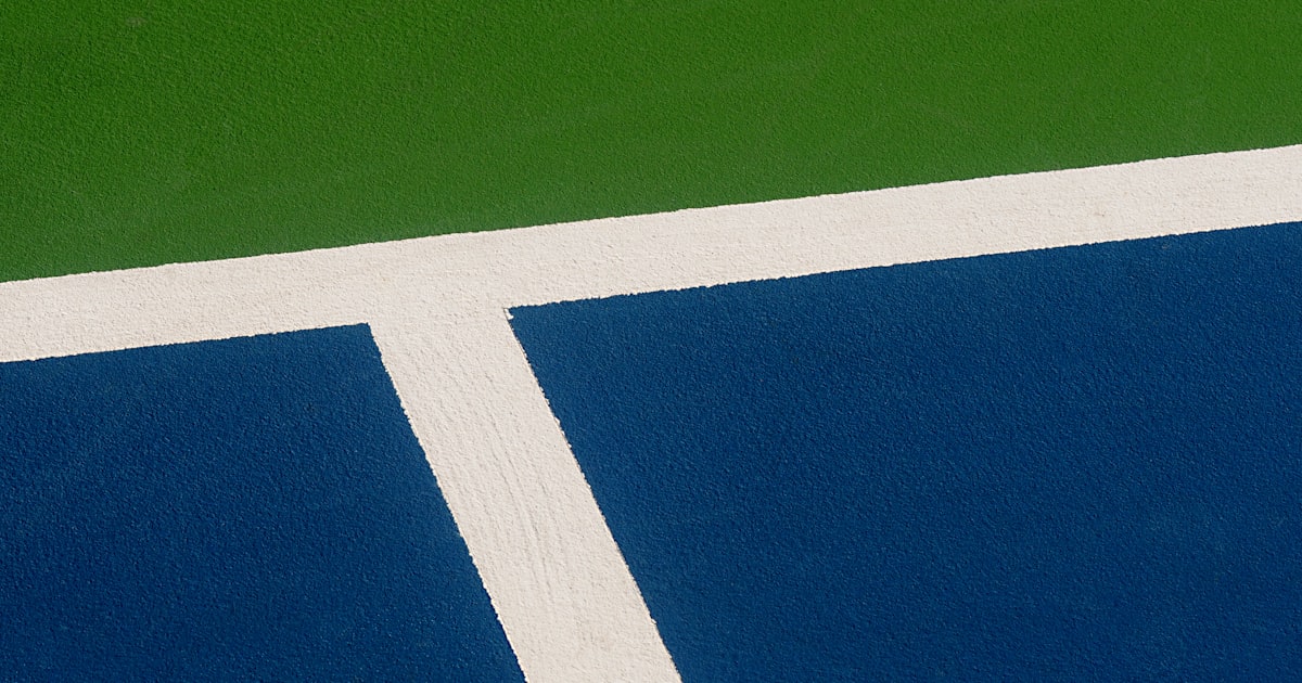 A pickleball player on a court holding a paddle