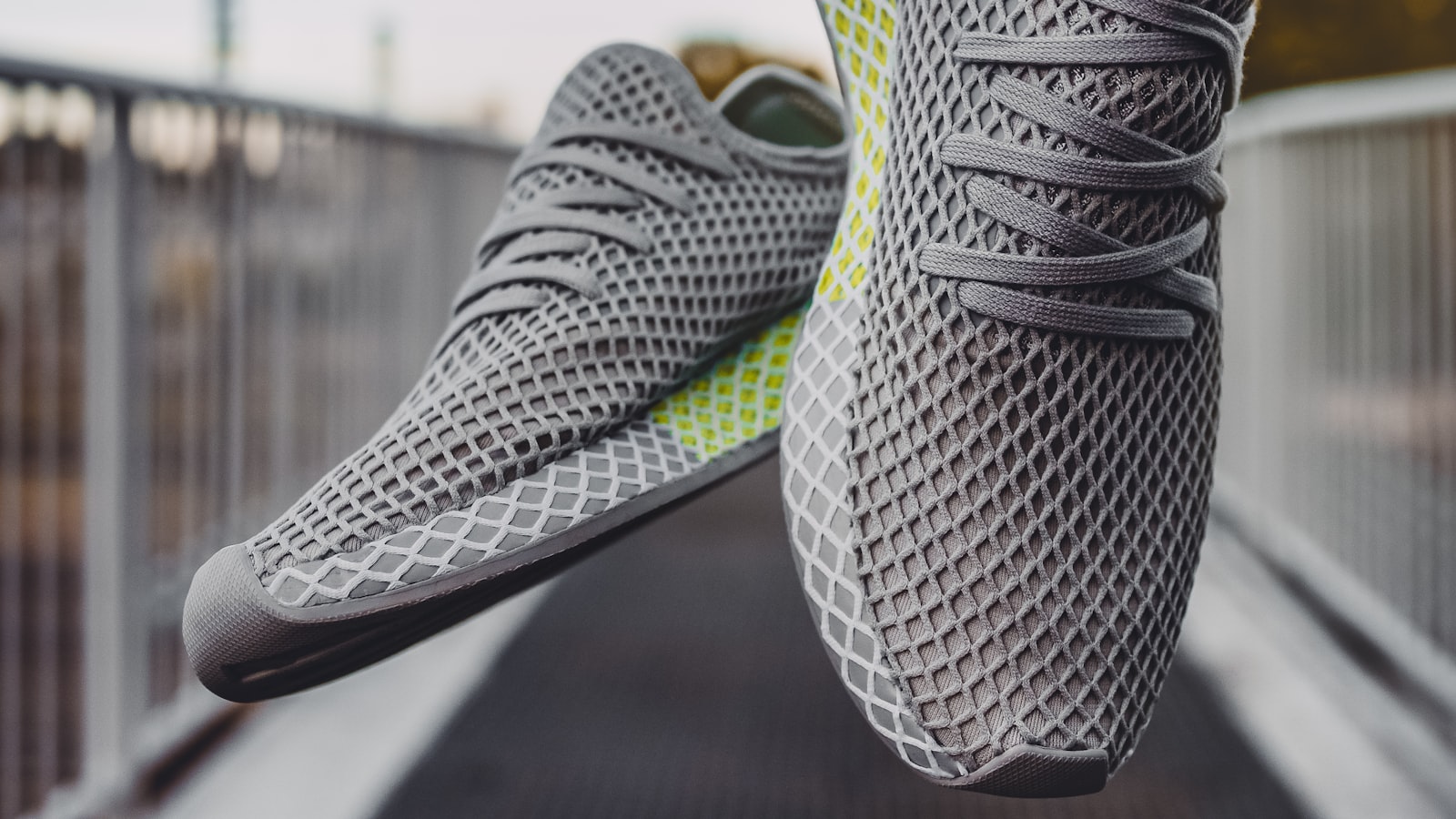 A pair of grey running shoes on a plain background