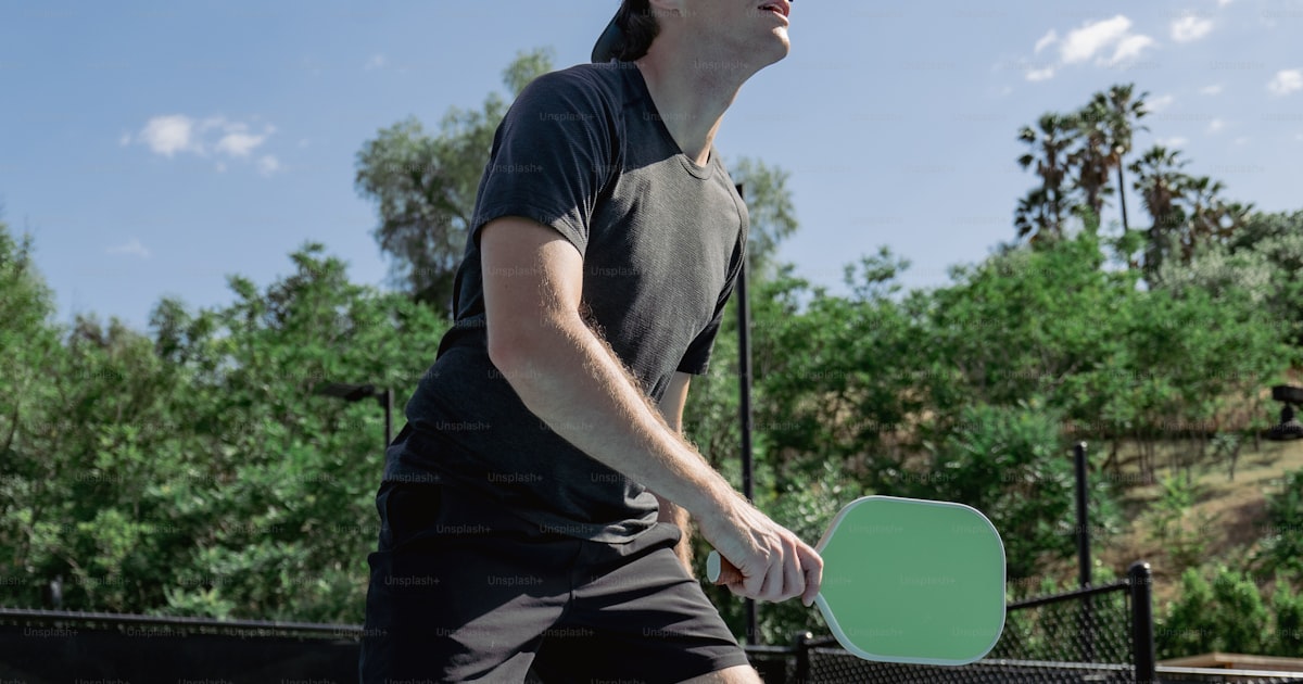 A man playing pickleball on a sunny day
